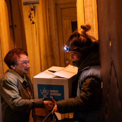A JDC aid worker delivers a humanitarian relief package to an elderly Ukrainian Jewish woman on Jan. 7, 2024.