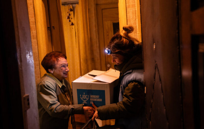 A JDC aid worker delivers a humanitarian relief package to an elderly Ukrainian Jewish woman on Jan. 7, 2024.