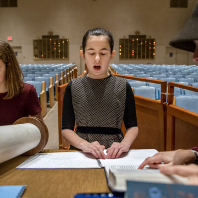 Illustrative. Batya Sperling Milner, who is blind, practices reading Torah with her aunt, Rachel Milner Gillers, and her friend Hannah Jaffee, during a rehearsal for her Bat-Mitzvah at Ohev Shalom synagogue in Washington, DC.
