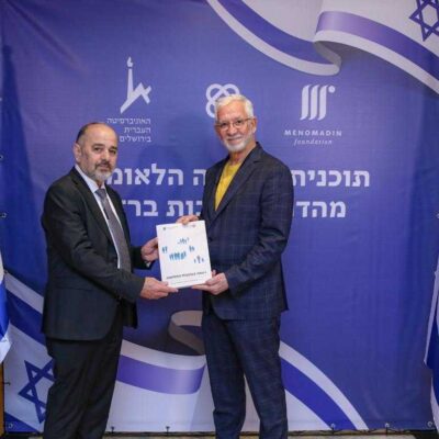 Haim Taib (right), founder and president of the Menomadin Foundation, hands a copy of a report to Israel Welfare Minister Yaakov Margi in March 2024.
