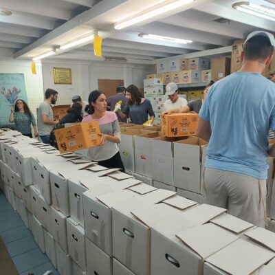 Birthright Israel participants pack boxes of food for soldiers and families in need at Beit Hatavshil, a Chabad soup kitchen in the Israeli town of Ofakim on June 25, 2024.