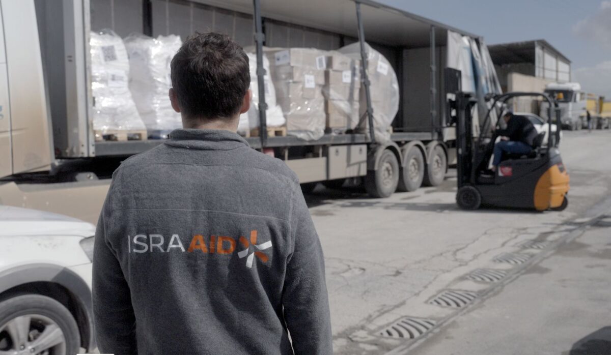 An IsraAid employee watches aid being delivered to Palestinians in the Gaza Strip, in an undated photograph.