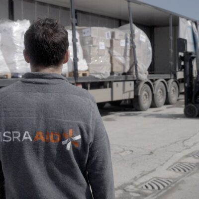 An IsraAid employee watches aid being delivered to Palestinians in the Gaza Strip, in an undated photograph.